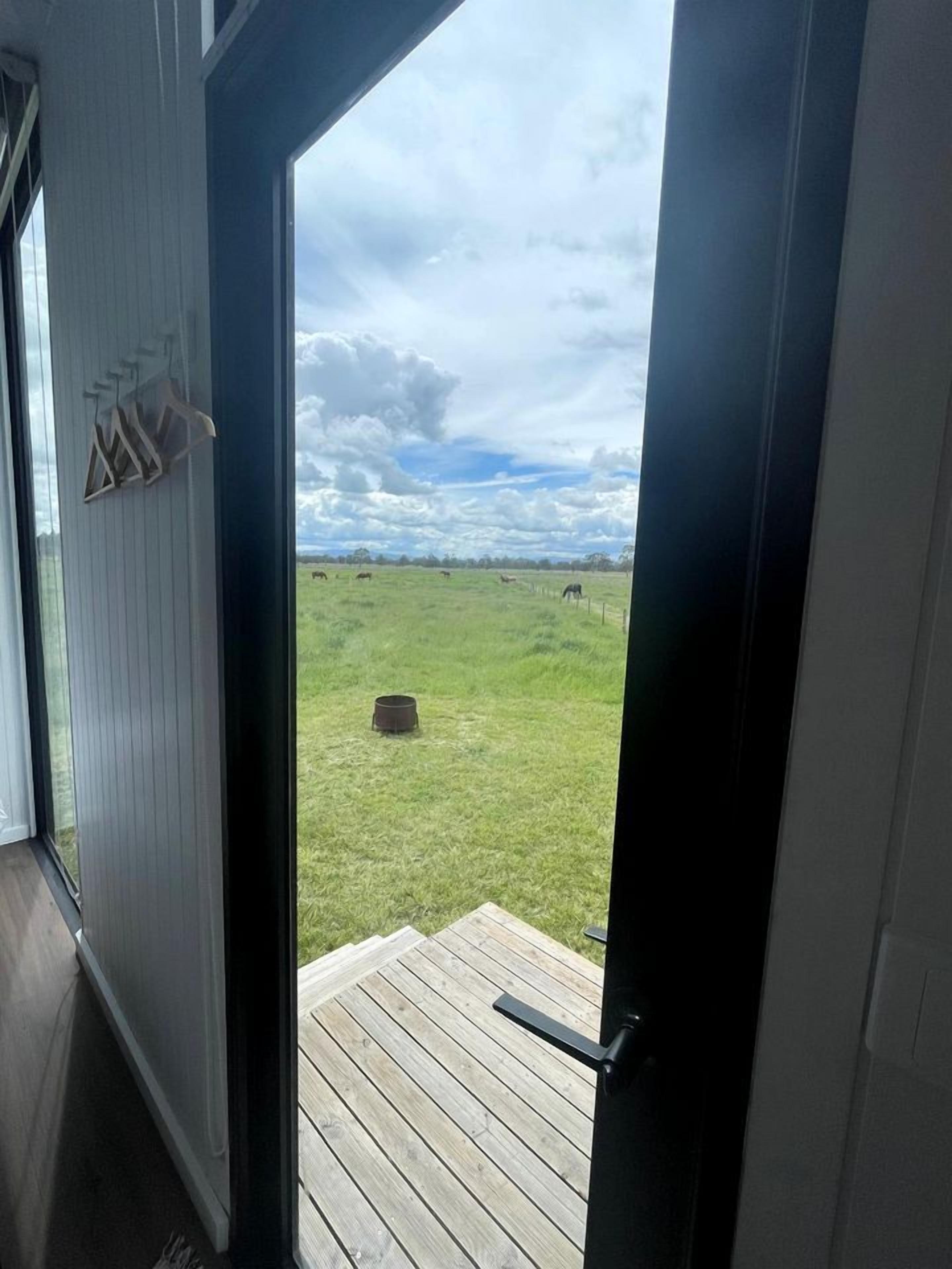 A view from inside a room with a door leading to a wooden deck.