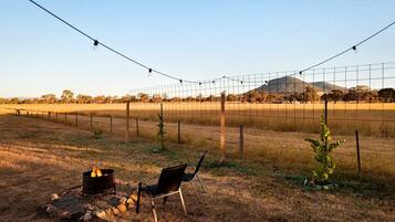 Un espacio al aire libre cercado con una silla y un brasero.