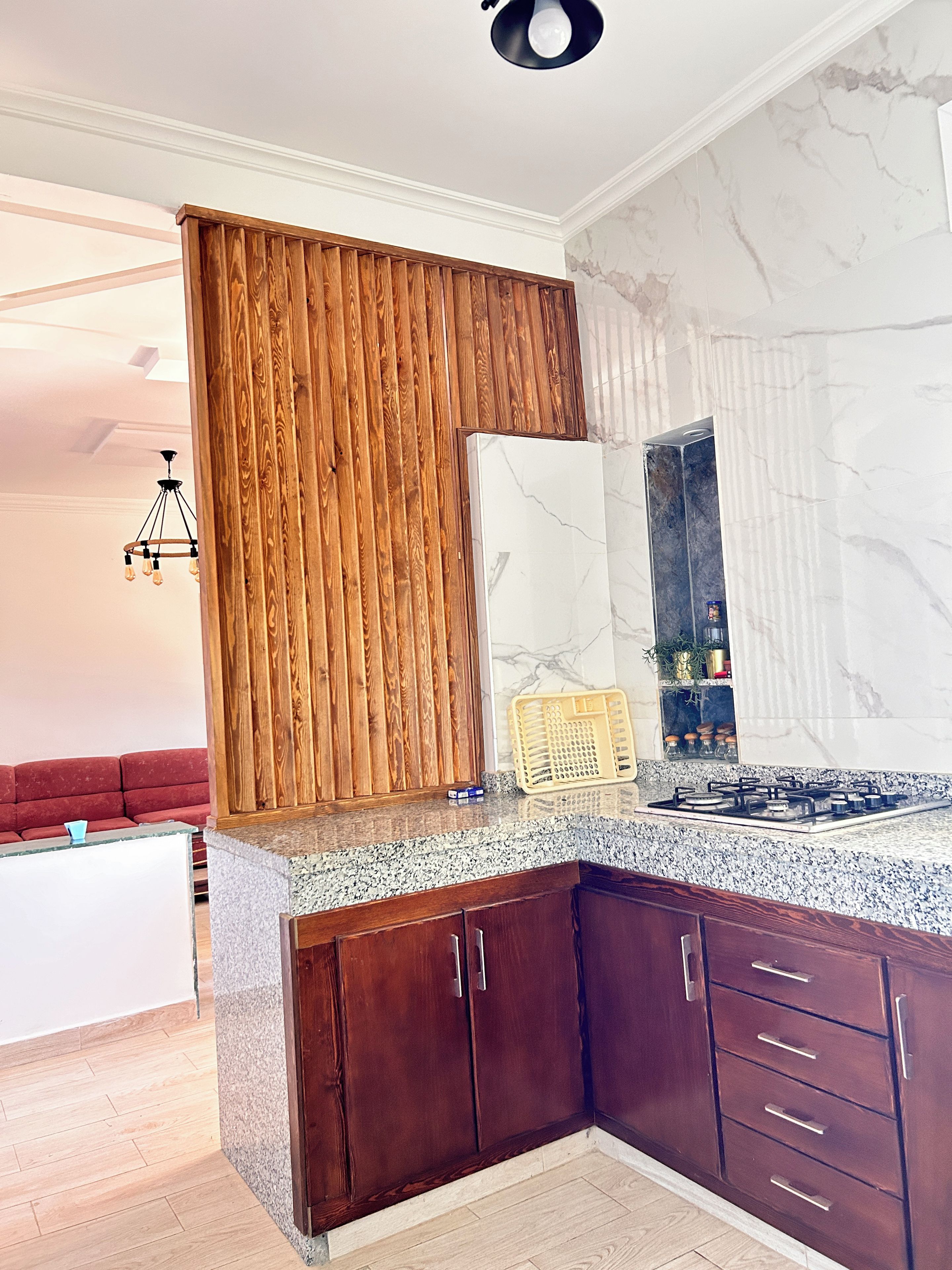 Une cuisine moderne avec des meubles en bois foncé, un plan de travail en granit et un pare-feu en marbre.