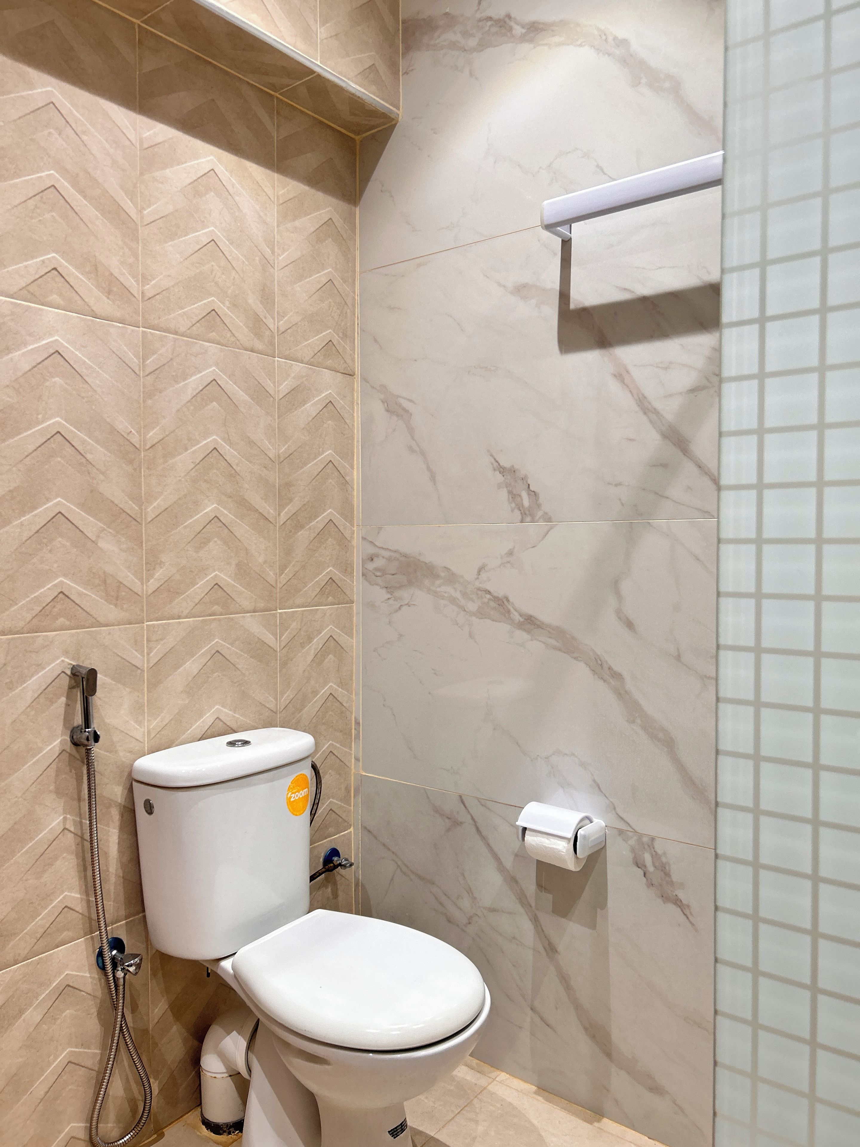 Ein Badezimmer mit Toilette, Dusche und Toilettenpapierhalter.