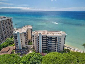A high-rise hotel with multiple balconies overlooking a beach and ocean. - New Luxury Retreat  Vast Ocean Views & Huge Lanai (Lahaina)
