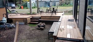 Una terrassa amb mobles d'exterior, una xemeneia i una zona de jardí.