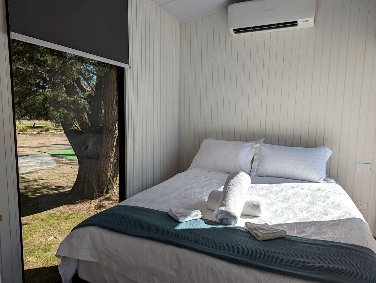 Une chambre d’hôtel équipée d’un lit, d’oreillers, d’une couverture et d’un appareil de climatisation.