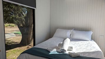 Une chambre d’hôtel équipée d’un lit, d’oreillers, d’une couverture et d’un appareil de climatisation.