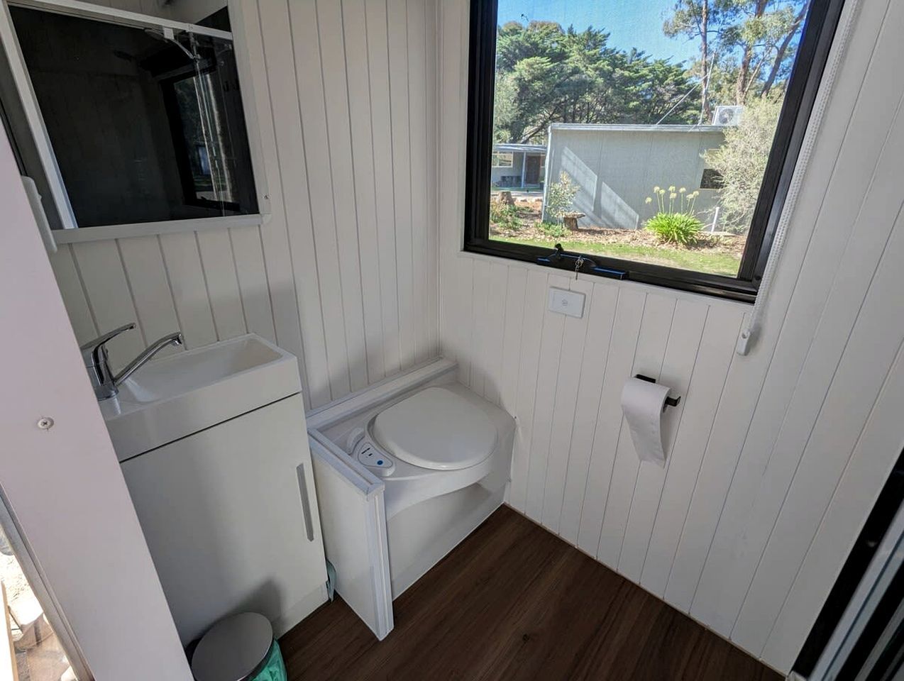 Une petite salle de bain comprenant des toilettes, un lavabo et une fenêtre.