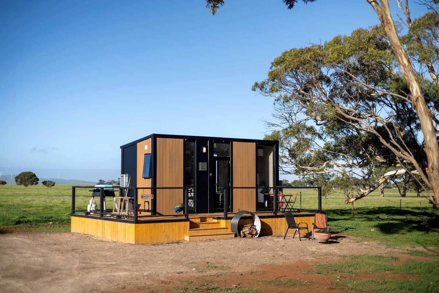 Eine moderne Holzhütte mit Terrasse und Blick auf die Landschaft.