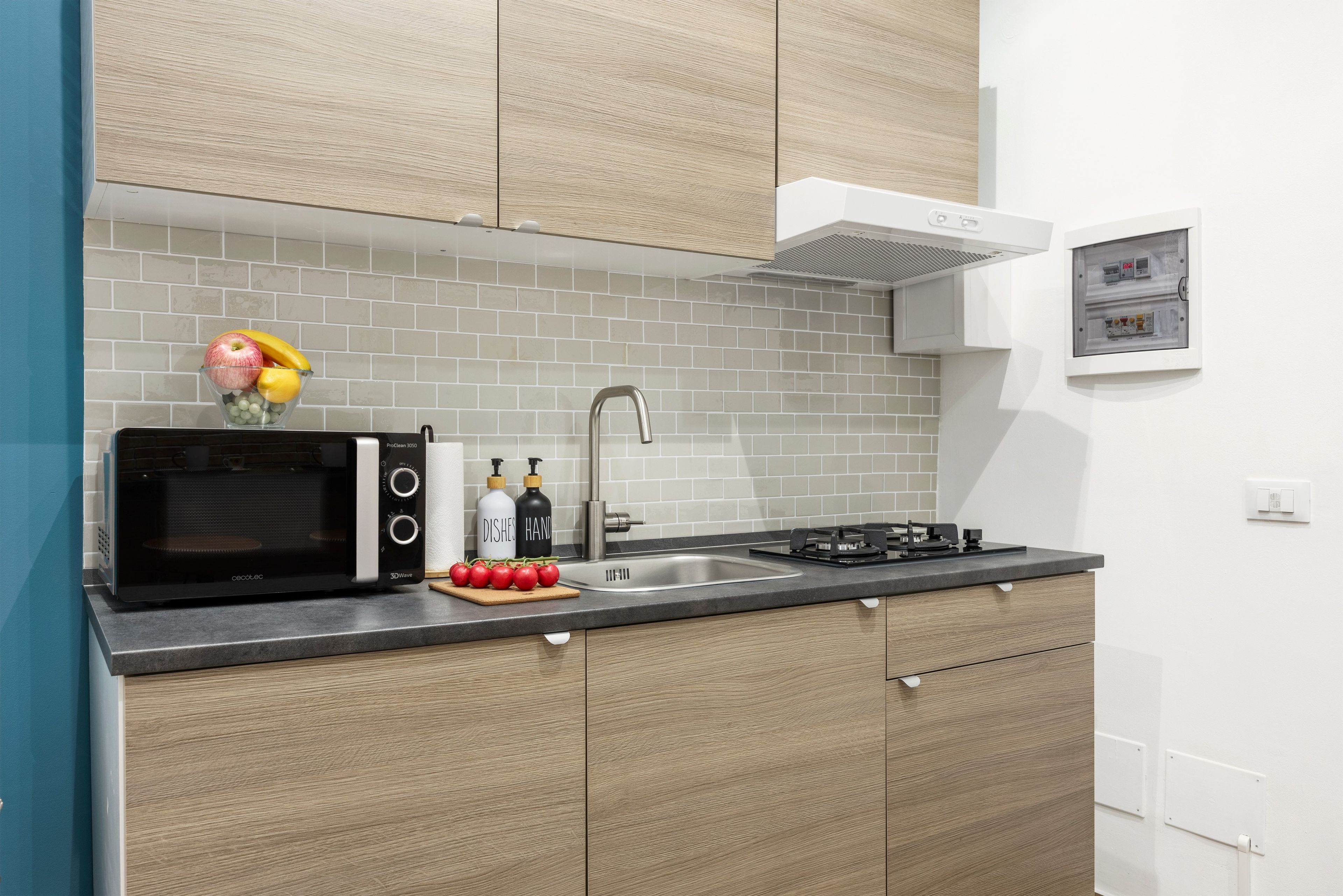 A modern kitchen with a microwave, sink, and stove.