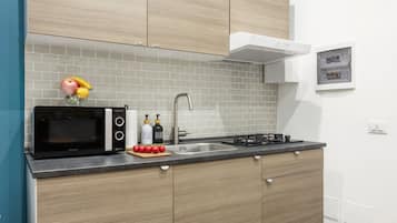 A modern kitchen with a microwave, sink, and stove.