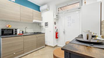 A modern kitchen with a microwave, stove, and a fire extinguisher.