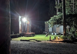 A campsite with a wooden structure, a table, and a trailer. - Dreamy Tiny House with Firepit, Tennis Court and Pool Table in Victoria, Australia (Dadswells Bridge)