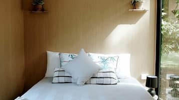 A bedroom with a bed, bedside table, and an air conditioning unit.