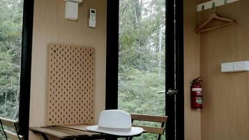 A room with a table and chairs, a fire extinguisher, and a door leading outside.