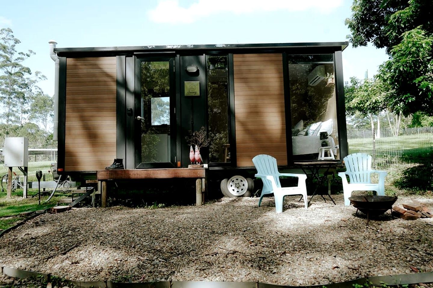 Eine kleine Holzhütte mit einer Bank und zwei Stühlen davor.