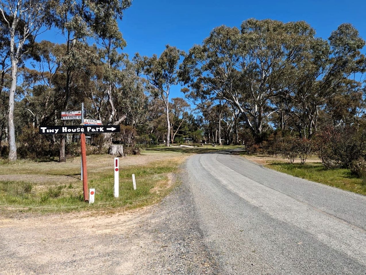 A road with a sign for Tiny House Park.