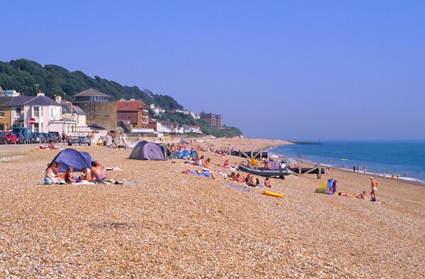 Une plage de galets avec des tentes et des gens.