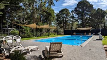 Una piscina con lettini e un'area ombreggiata.
