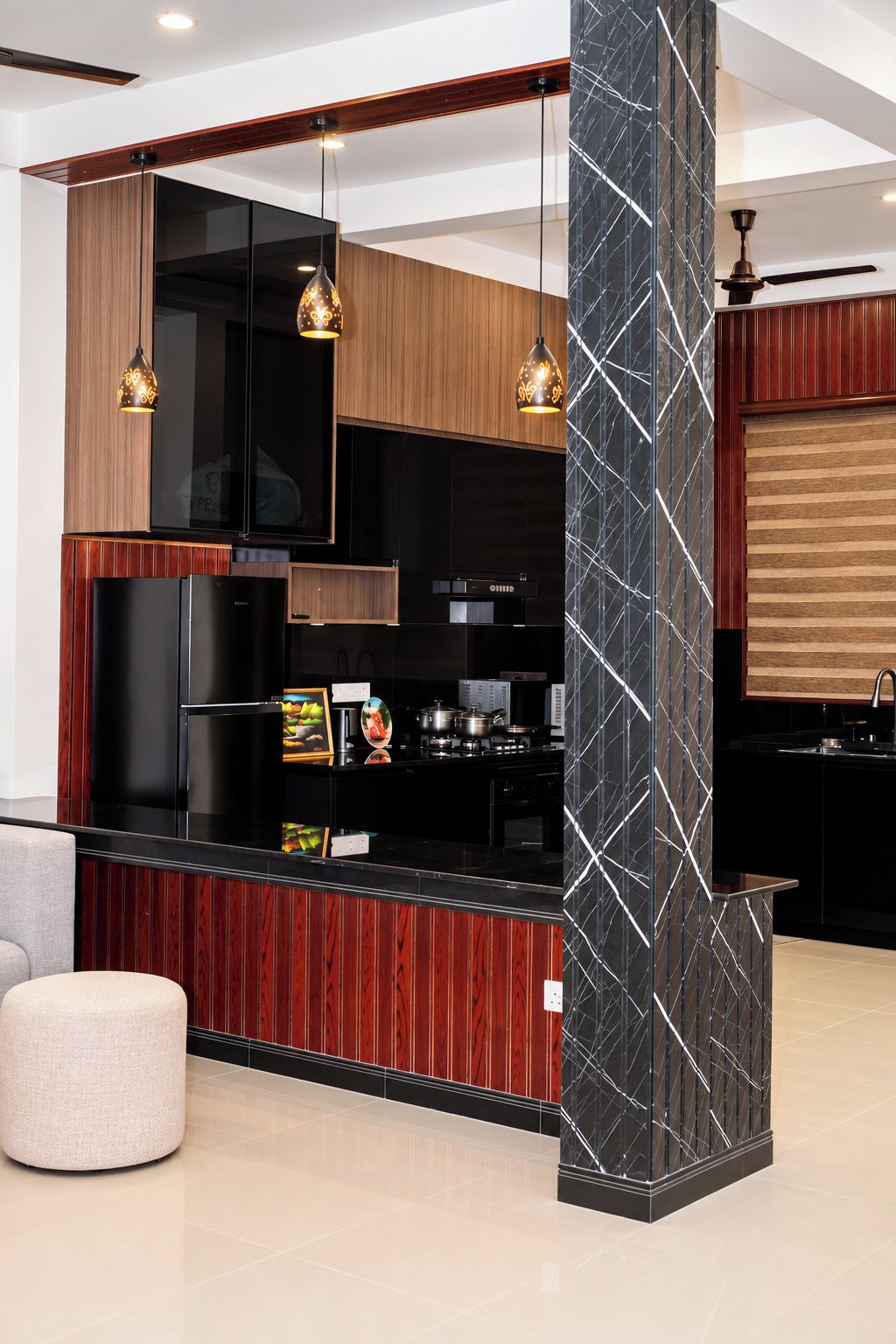 A modern kitchen with a black countertop, wooden cabinets, and pendant lighting.