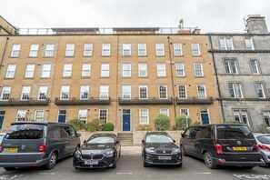 A row of townhouses with a uniform facade, multiple windows, and a central entrance. - Beautiful 1-Bed on Brunswick | Edinburgh East End - Pass the Keys (Edinburgh)