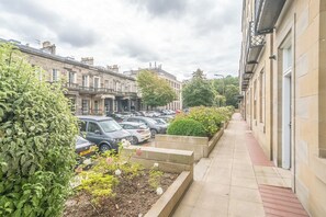 A row of parked cars along a sidewalk with a building on the right and a row of houses on the left. - Beautiful 1-Bed on Brunswick | Edinburgh East End - Pass the Keys (Edinburgh)