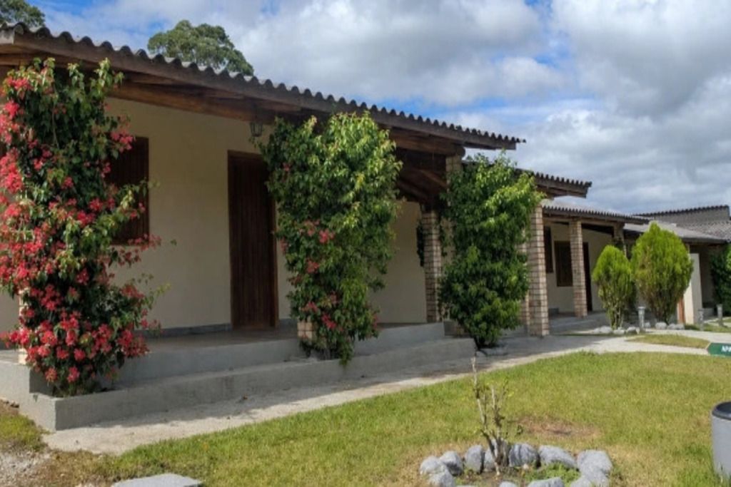 Un edificio residencial con un porche cubierto, un sendero de ladrillo y un césped bien cuidado.