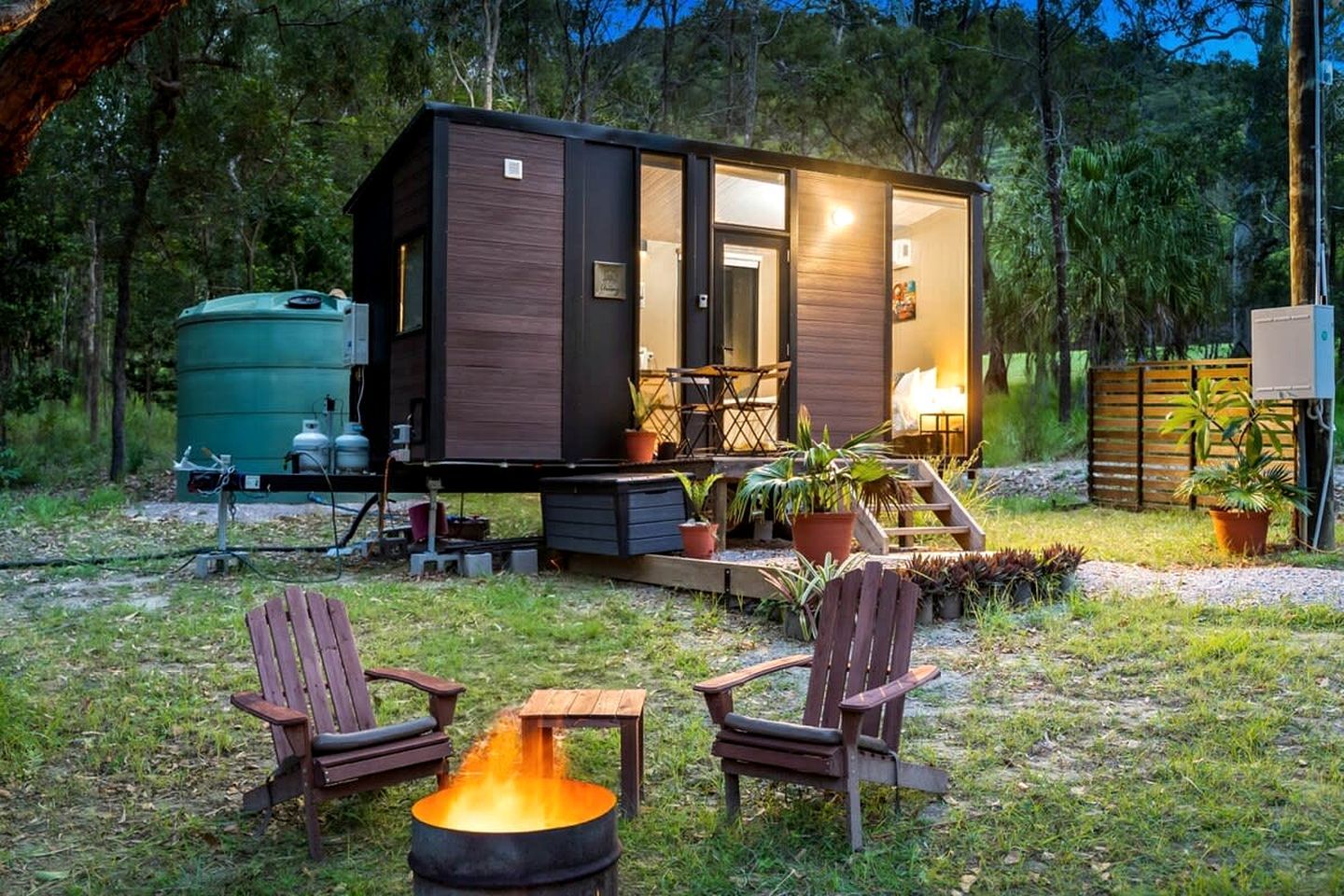 Una cabaña con porche, mobiliario exterior y un brasero.