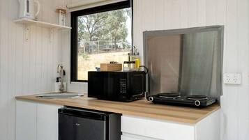 A compact kitchen with a microwave, a coffee maker, and a dishwasher.