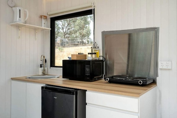 A compact kitchen with a microwave, a coffee maker, and a dishwasher.