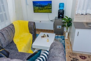 A living room with a sofa, a coffee table, and a television mounted on the wall. - An good place to be,with Mt Kenya view,a quiet place ,with a spacious parking (Nanyuki)