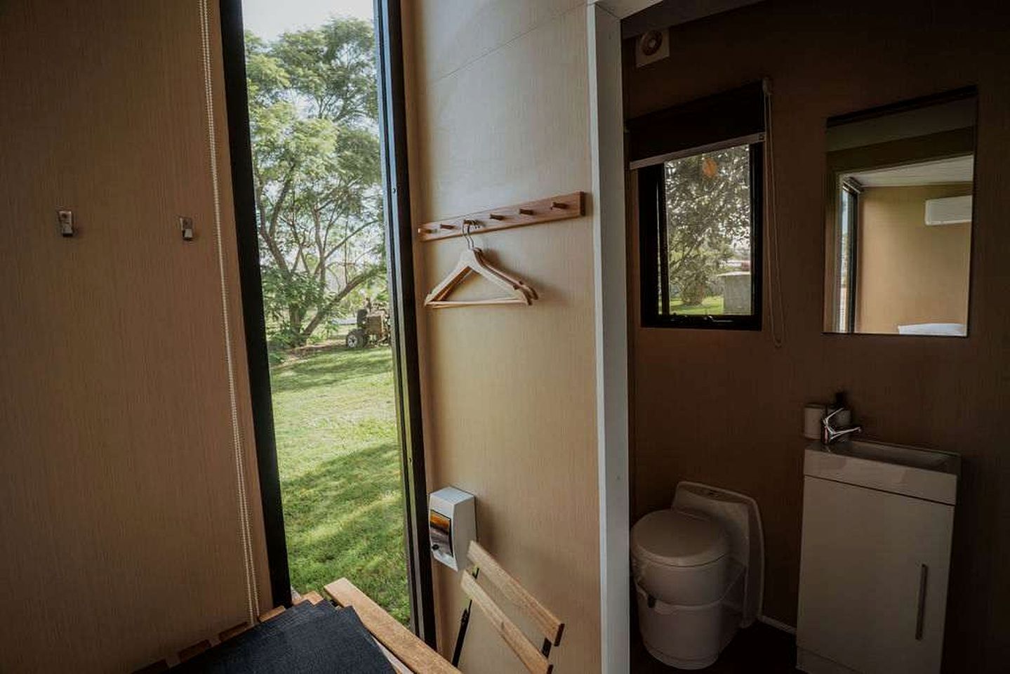 Une petite salle de bain comprenant des toilettes, un lavabo et une petite fenêtre.