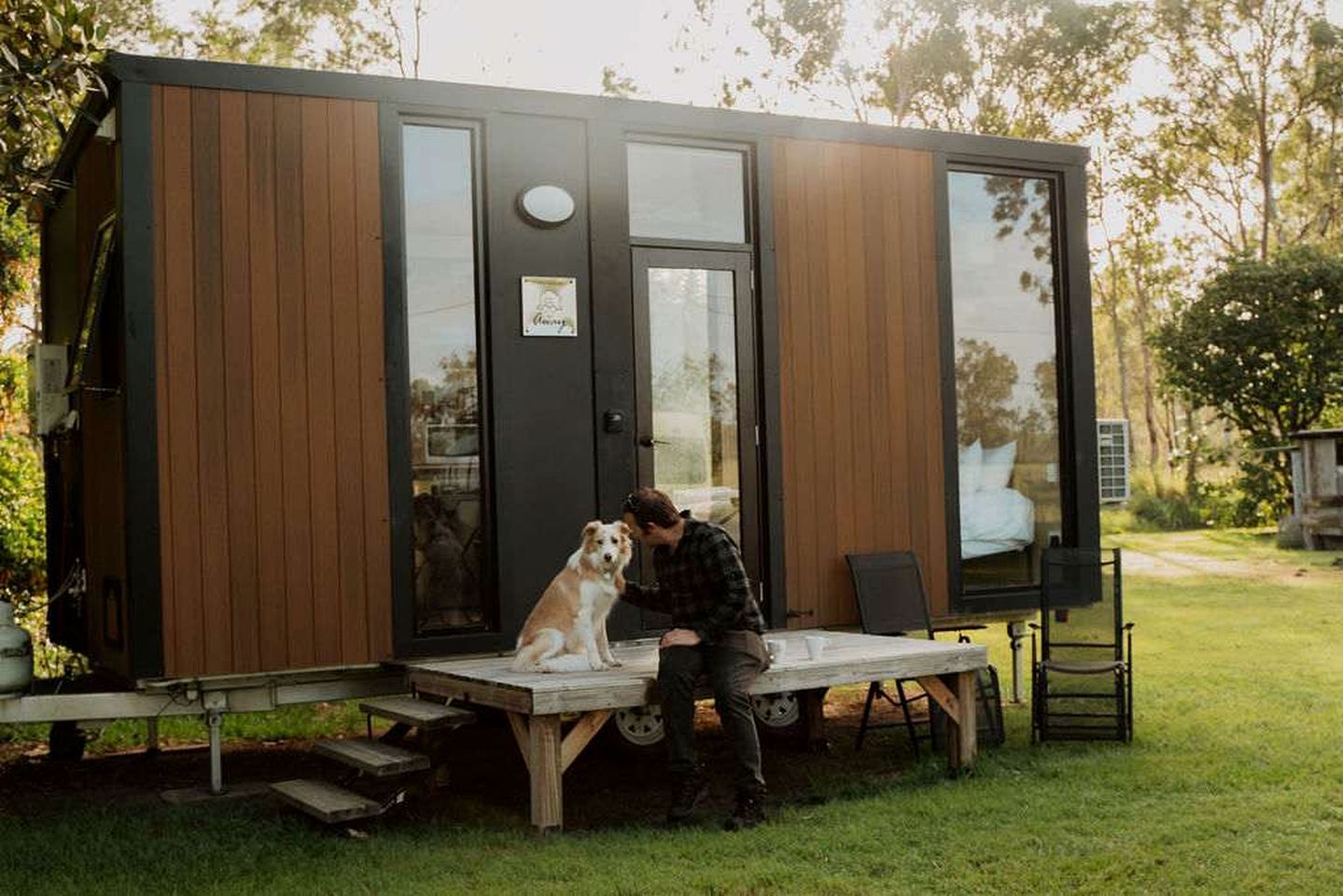 Una casa moderna y compacta con fachada de madera y amplias ventanas.