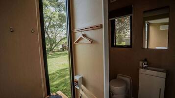 A compact bathroom with a toilet, sink, and a small window.