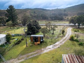 A rural property with a small cabin, a dirt path, and surrounding vegetation.