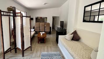 Una sala de estar con sofá, mesa de centro, televisión y un comedor con sillas y mesa.