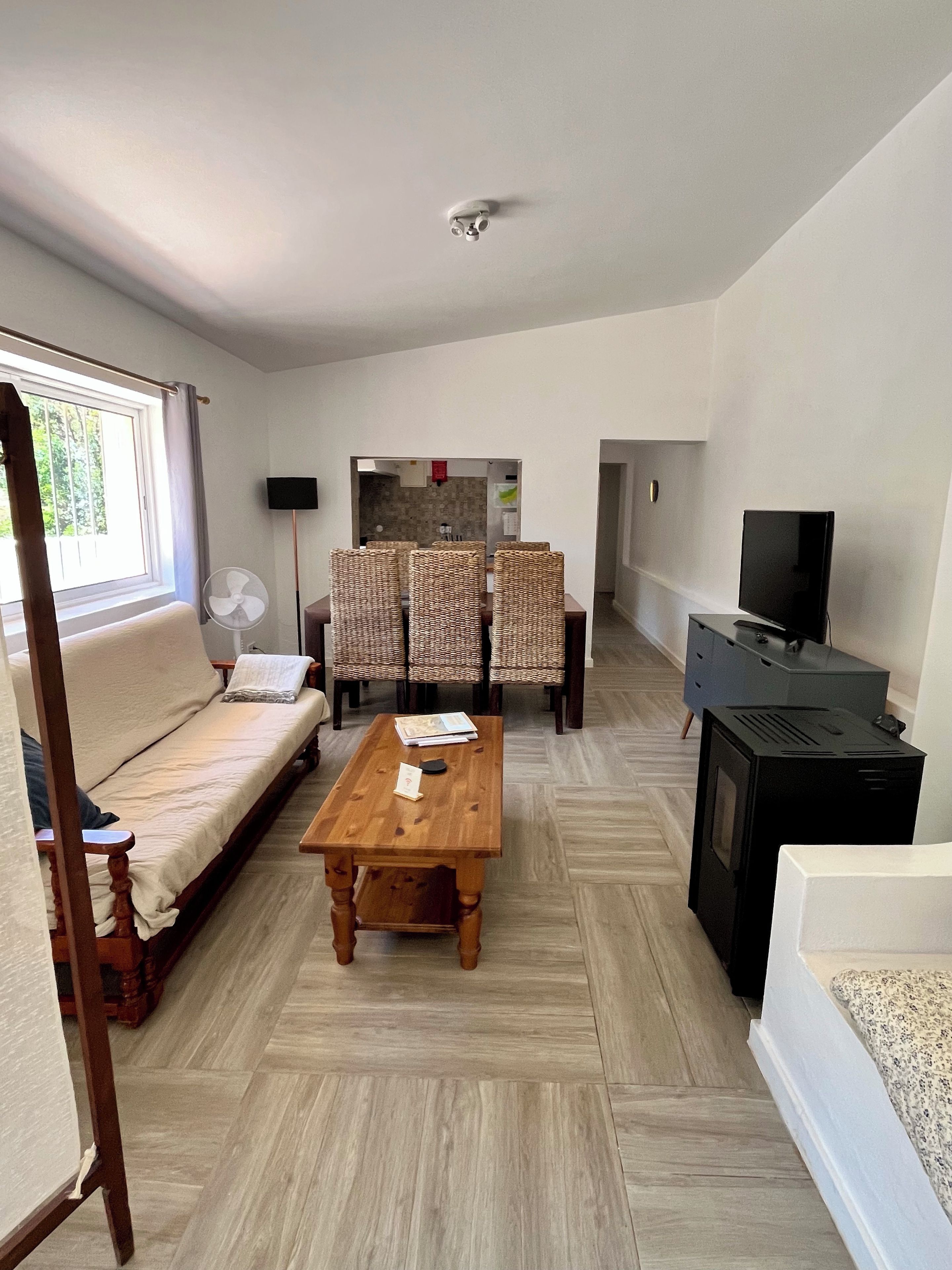 Een woonkamer met een bank, een houten salontafel, een televisie en een open haard.