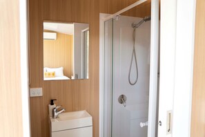 A bathroom with a shower, a sink, and a mirror.