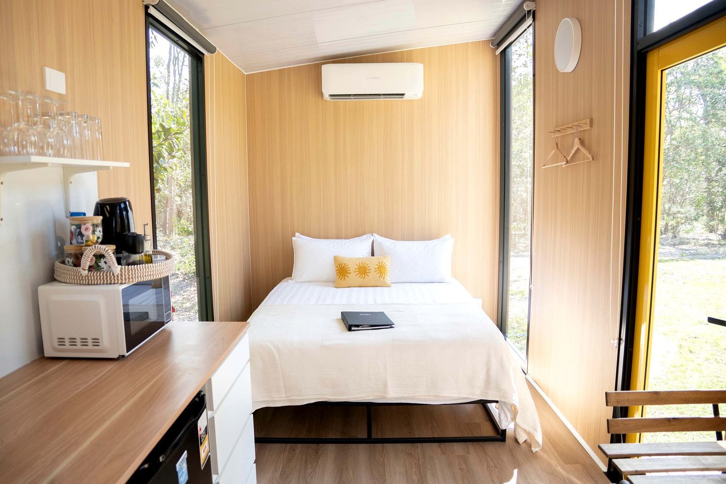Ein modernes Zimmer mit einem Bett, einem Nachttisch und einem Fenster.