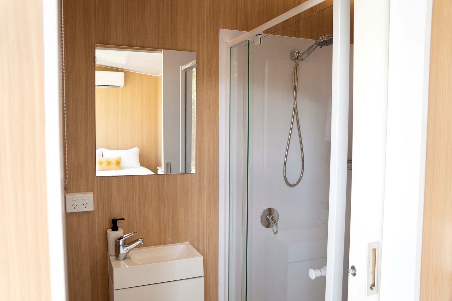 Une salle de bain avec une douche, un lavabo et un miroir.