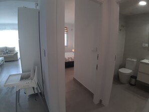 A modern, minimalist bathroom with a toilet, sink, and trash bin. - Groundfloor Lopagan (San Pedro del Pinatar)