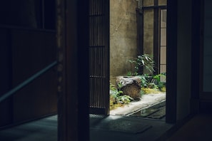 Un interior japonés tradicional con puertas correderas, un farol de piedra y un pequeño jardín.