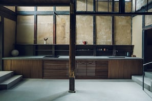Una cocina moderna con encimera de hormigón, armarios de madera y un amplio ventanal.