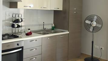 Een moderne keuken met een gasfornuis, oven en een inbouwafzuigkap.