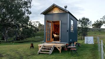 Eine kleine, eingeschossige Holzhütte mit einer Holztür und einer Rampe zum Eingang.
