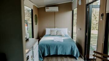 A bedroom with a bed, a desk, and a window.