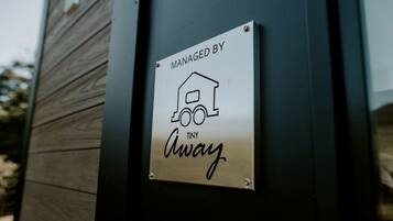 A sign with a house icon and the text 'MANAGED BY Tiny Away.'