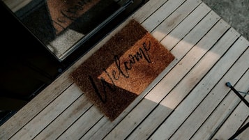 A wooden deck with a welcome mat.
