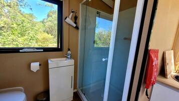 Ein kleines Badezimmer mit Toilette, Waschbecken und Duschbereich.