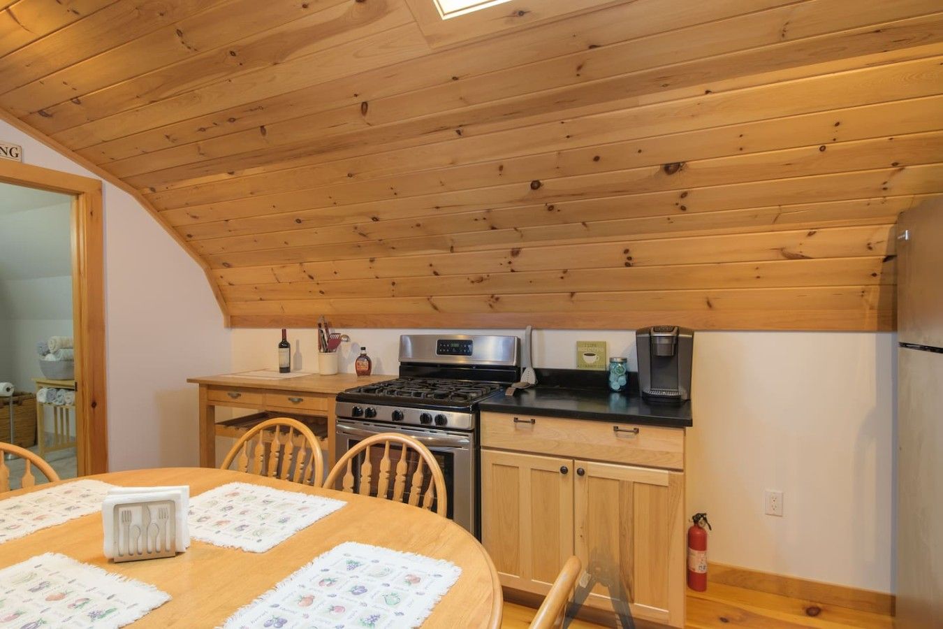 Eine Küche mit Holzboden, einem Herd, einer Mikrowelle und einem Kühlschrank.