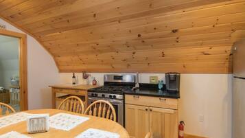 Eine Küche mit Holzboden, einem Herd, einer Mikrowelle und einem Kühlschrank.