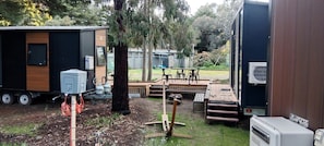 Una casa móvil con terraza, mobiliario exterior y un pequeño jardín.