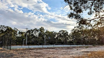 Un'area esterna recintata con alberi e un cielo sereno.